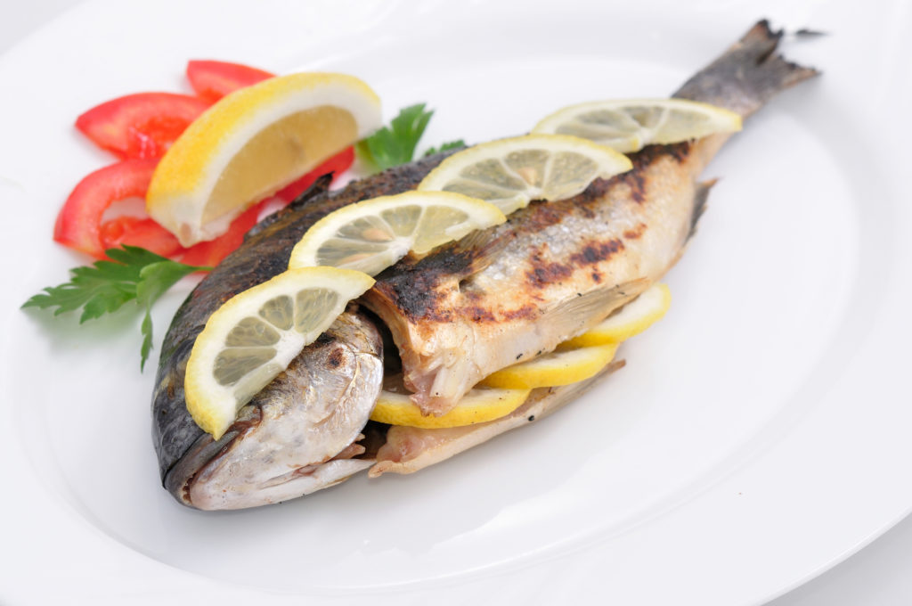Fresh grilling fish with lemons and herbs